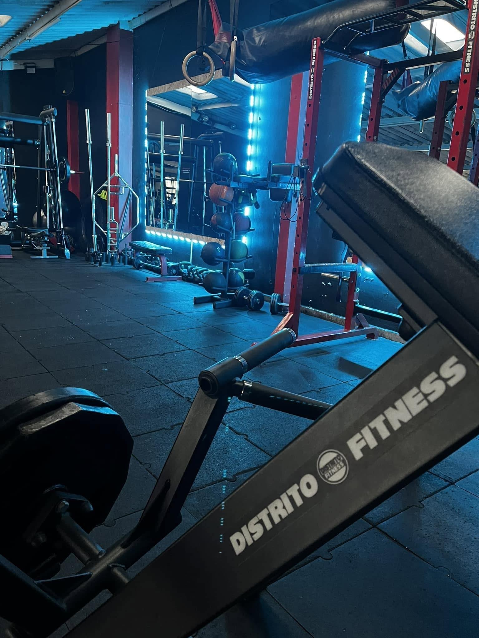 Sala de pesas actual de Distrito Fitness con racks personalizados e iluminación LED