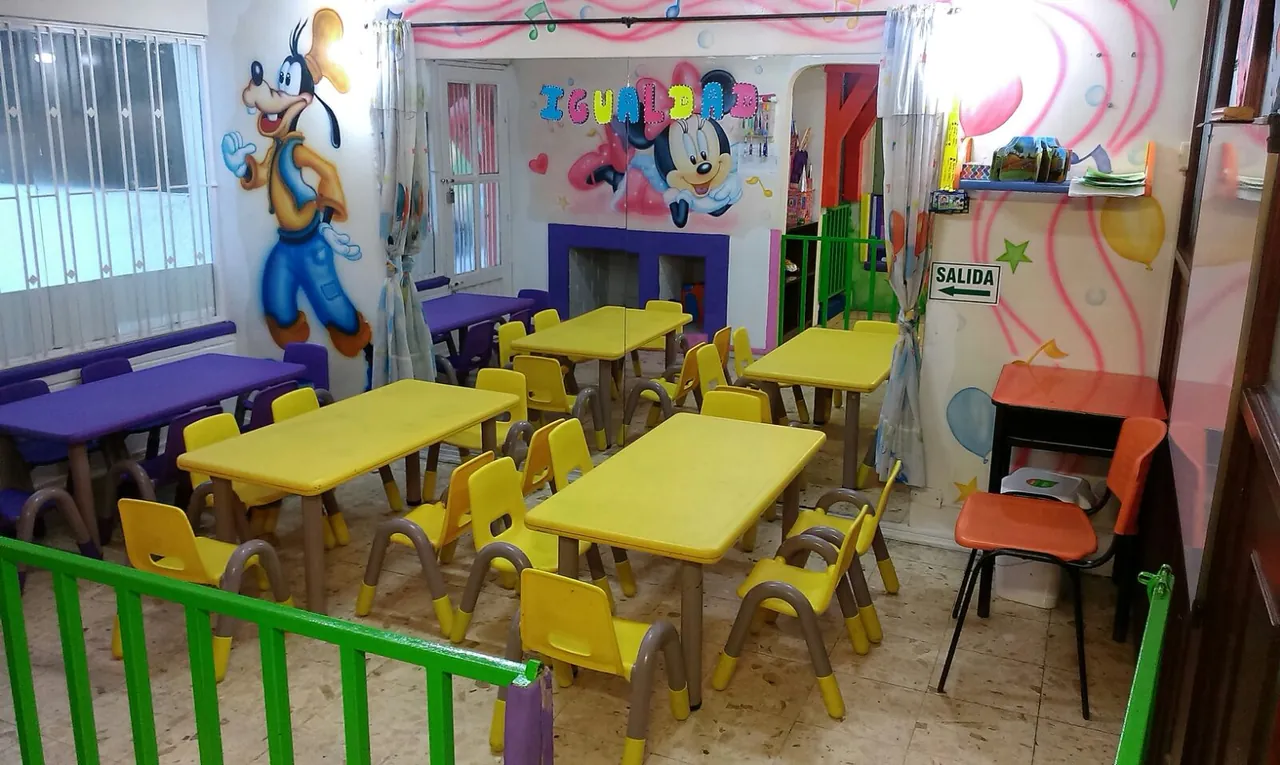 Salón de clases con mesas infantiles y decoración temática