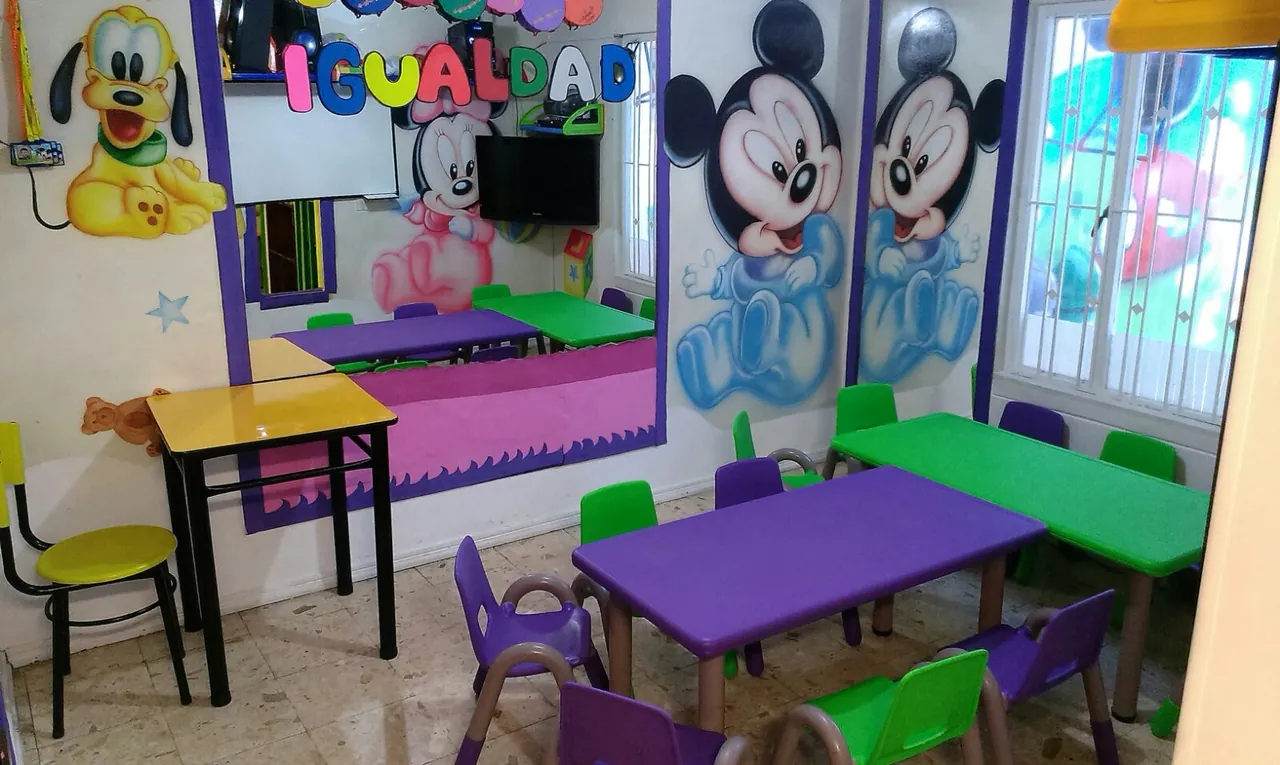 Aula con mobiliario infantil y murales educativos con el valor de la igualdad